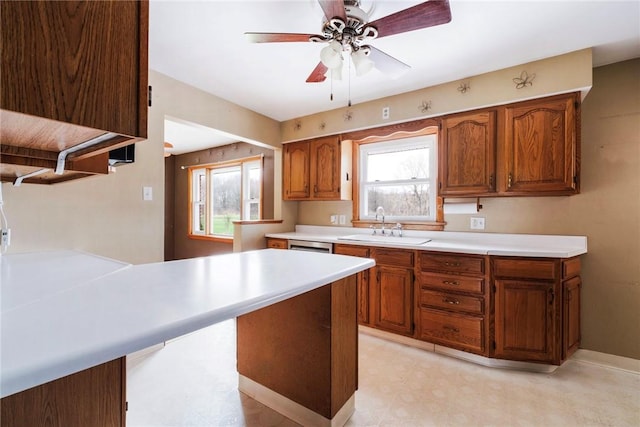kitchen featuring light countertops, brown cabinets, a sink, and light floors