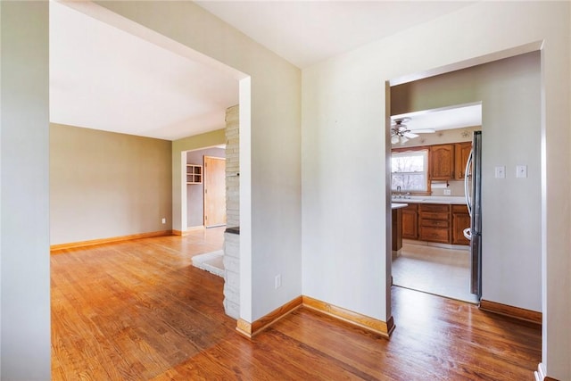 hallway with light wood-style flooring and baseboards