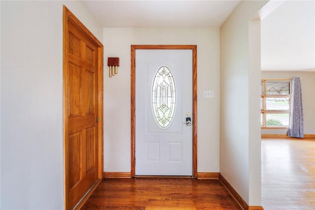 foyer entrance with wood finished floors and baseboards