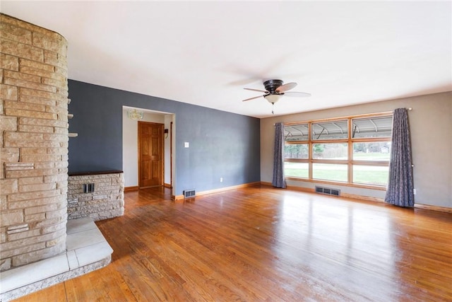 unfurnished living room featuring ceiling fan, baseboards, visible vents, and wood finished floors