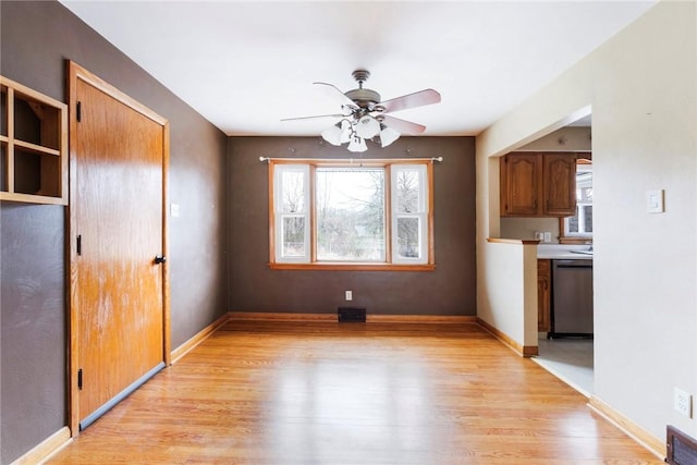 unfurnished dining area with a wealth of natural light, light wood-style floors, visible vents, and a ceiling fan