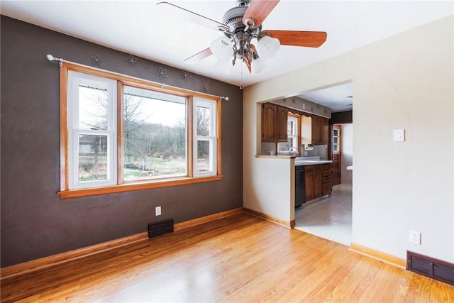 unfurnished living room with light wood-style floors, visible vents, baseboards, and ceiling fan