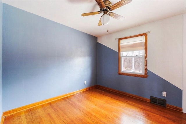 spare room with light wood finished floors, visible vents, baseboards, and ceiling fan