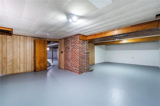 finished basement featuring wood walls