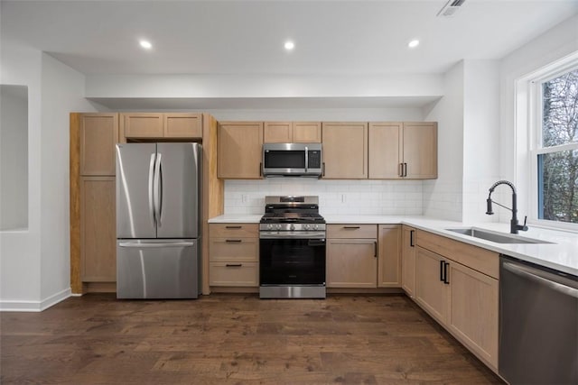 1523 Westmoreland Ave, Lincoln-Larimer, PA 15206 - kitchen featuring dark wood-type flooring, light brown cabinetry, appliances with stainless steel finishes, a sink, and decorative backsplash