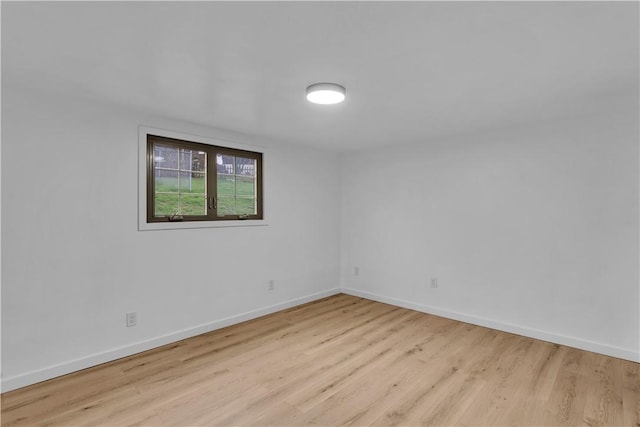 spare room featuring baseboards and wood finished floors