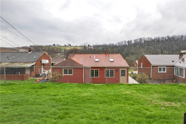 back of property with fence and a lawn
