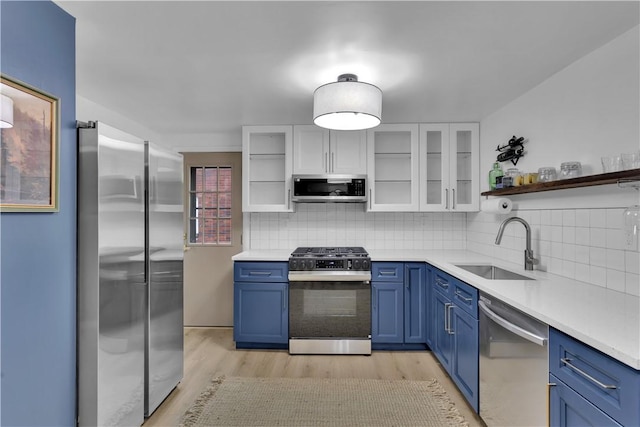 kitchen with a sink, light countertops, blue cabinets, and stainless steel appliances