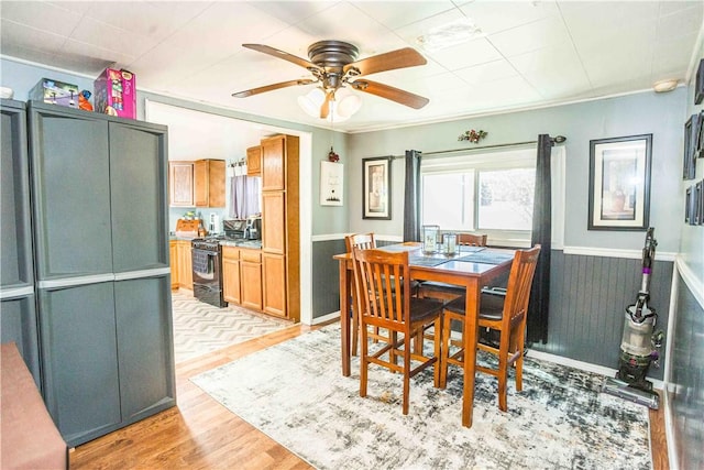 448 E Main St, Dayton, PA 16222 - dining space featuring wainscoting, light wood-type flooring, and a ceiling fan