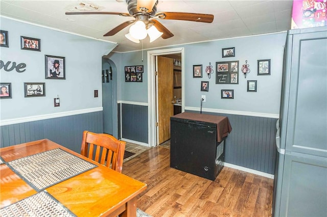 448 E Main St, Dayton, PA 16222 - dining space featuring ceiling fan, arched walkways, wainscoting, and wood finished floors