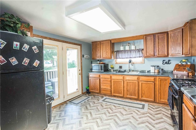 448 E Main St, Dayton, PA 16222 - kitchen with a sink, brown cabinetry, black appliances, and light floors