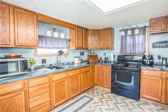 448 E Main St, Dayton, PA 16222 - kitchen with brown cabinetry, a sink, stainless steel microwave, and black range with gas stovetop