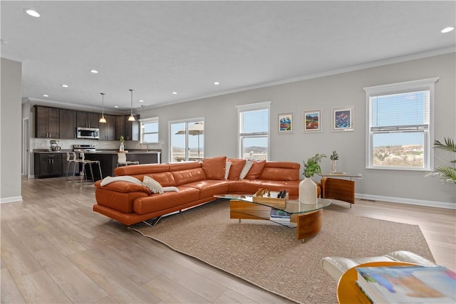 living room featuring ornamental molding, light wood-type flooring, recessed lighting, and baseboards