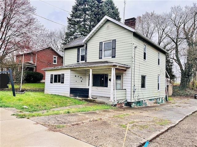 506 E Division St, New Castle/5Th, PA 16101 - view of front of home featuring covered porch, a chimney, and a front lawn