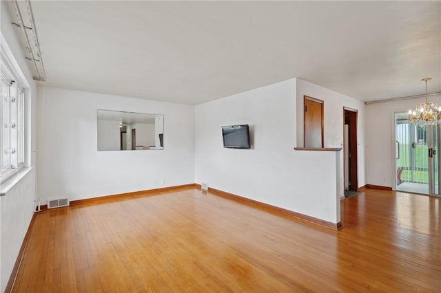 126 Peony Ave, Ross Twp, PA 15229 - spare room with baseboards, visible vents, a notable chandelier, and wood-type flooring