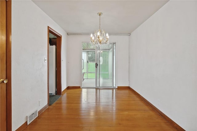 126 Peony Ave, Ross Twp, PA 15229 - unfurnished dining area featuring a notable chandelier, visible vents, light wood-style flooring, and baseboards