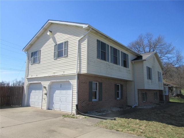 view of side of property with a garage, a yard, brick siding, and concrete driveway