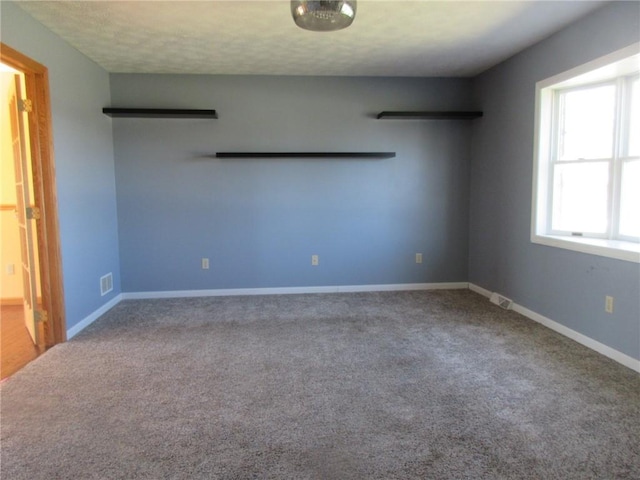 carpeted spare room with baseboards and visible vents