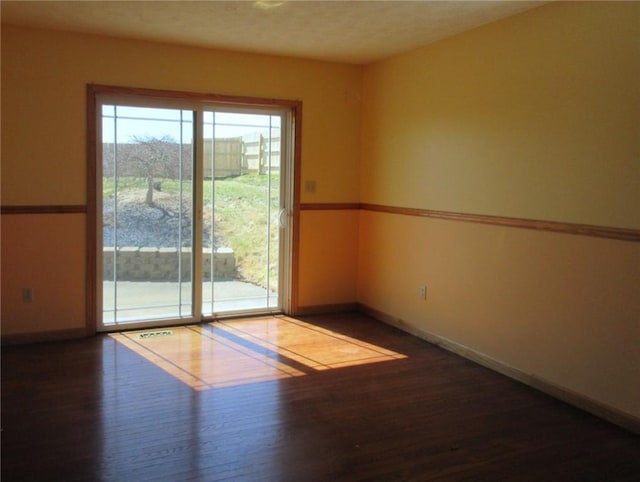 spare room with wood finished floors and baseboards