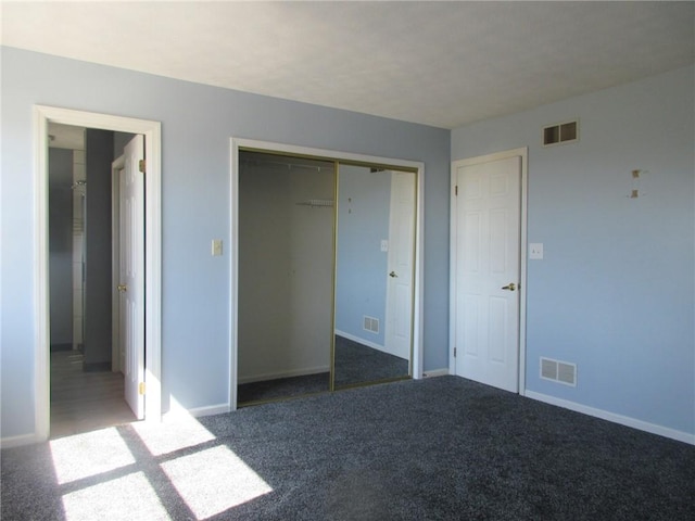 unfurnished bedroom featuring carpet flooring, visible vents, and a closet