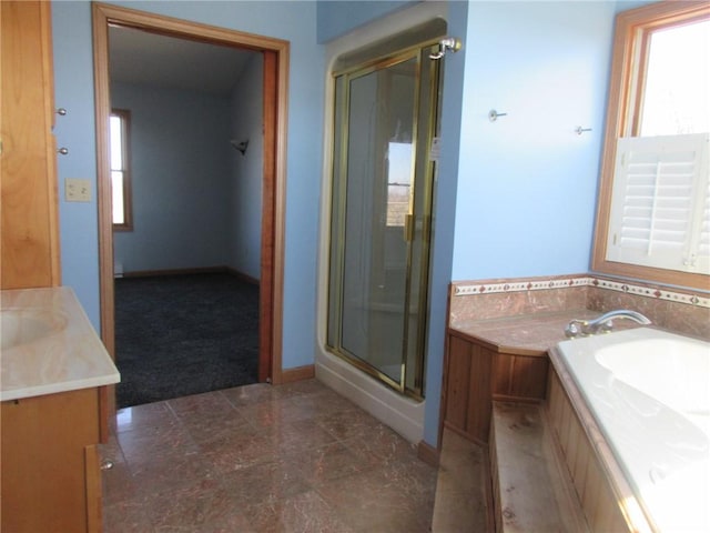 bathroom with a bath, a stall shower, vanity, and baseboards