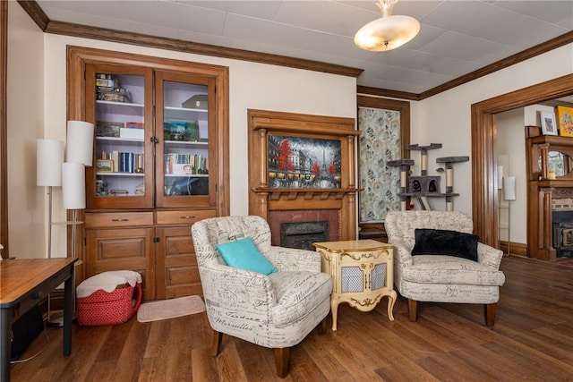 living area with a fireplace, dark wood-style floors, and ornamental molding