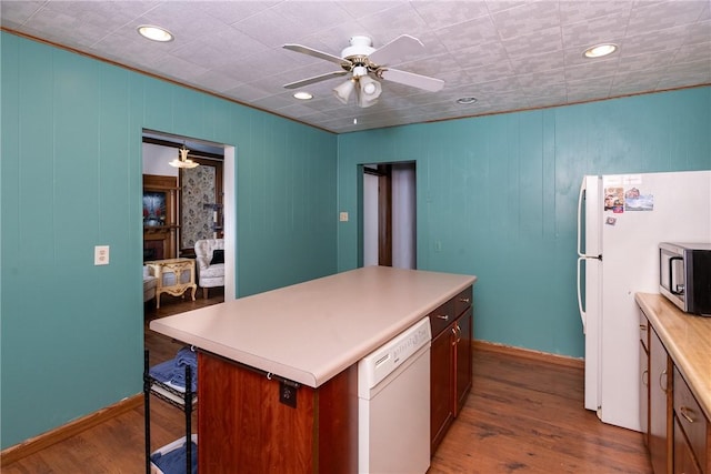 kitchen featuring stainless steel microwave, wood finished floors, dishwasher, and a ceiling fan