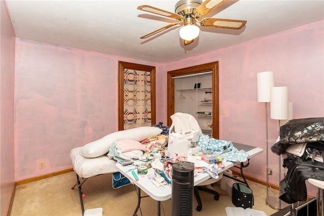 dining space featuring baseboards, light colored carpet, and ceiling fan