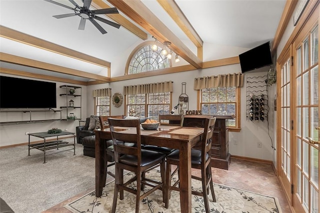 dining room with a ceiling fan, baseboards, a wealth of natural light, and vaulted ceiling with beams