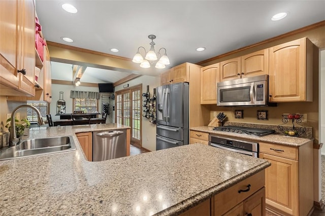 kitchen featuring appliances with stainless steel finishes, light brown cabinetry, a sink, a peninsula, and recessed lighting