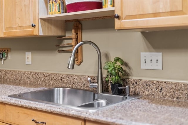 room details featuring a sink, open shelves, and light brown cabinetry