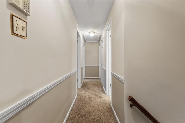 hall featuring light colored carpet, attic access, and an upstairs landing