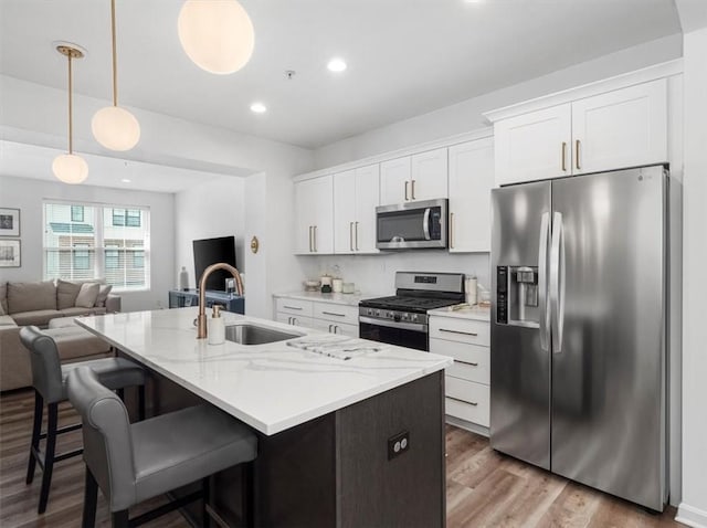 308 Thurgood Dr, Marshall, PA 15086 - kitchen featuring white cabinets, a sink, appliances with stainless steel finishes, an island with sink, and wood finished floors
