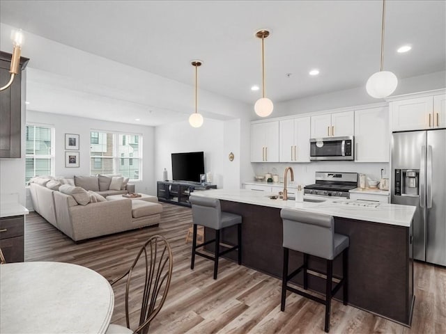 308 Thurgood Dr, Marshall, PA 15086 - kitchen featuring a kitchen bar, wood finished floors, light countertops, a sink, and stainless steel appliances