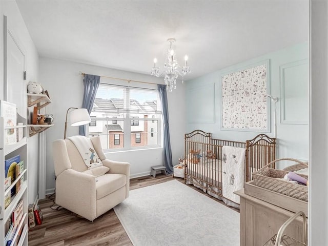 308 Thurgood Dr, Marshall, PA 15086 - bedroom with baseboards, an inviting chandelier, a nursery area, and wood finished floors