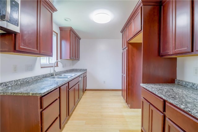 1282 Cook School Rd, Bridgeville, PA 15017 - kitchen with stainless steel microwave, baseboards, light wood-style floors, a sink, and reddish brown cabinets