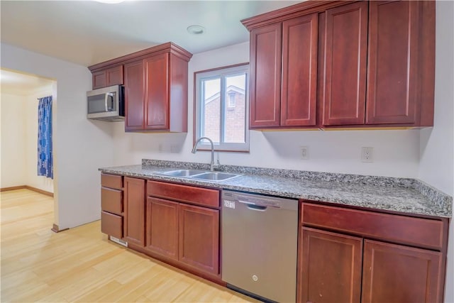 1282 Cook School Rd, Bridgeville, PA 15017 - kitchen with a sink, reddish brown cabinets, light wood finished floors, and stainless steel appliances