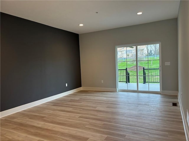 unfurnished room featuring light wood-style flooring, baseboards, and recessed lighting