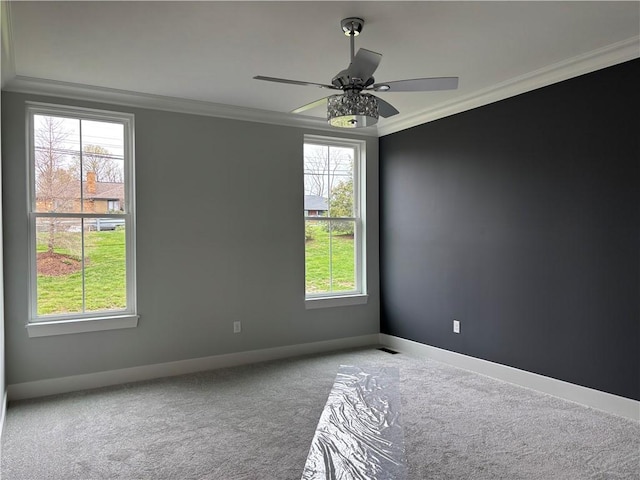 carpeted spare room featuring ceiling fan, baseboards, and ornamental molding