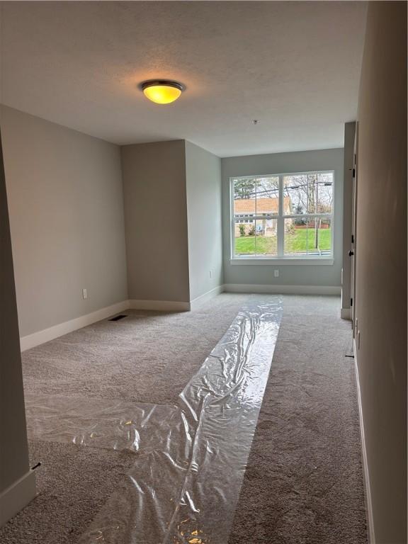 carpeted spare room with baseboards