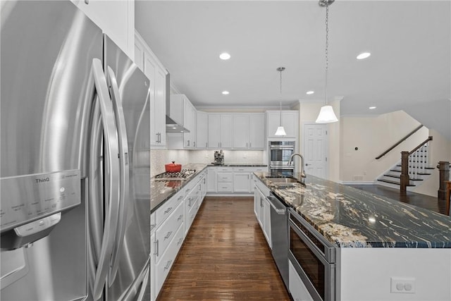 kitchen with white cabinets, a sink, stainless steel appliances, a large island with sink, and dark wood finished floors