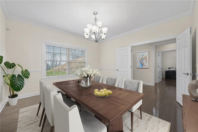 dining area with wood finished floors, crown molding, a notable chandelier, and baseboards