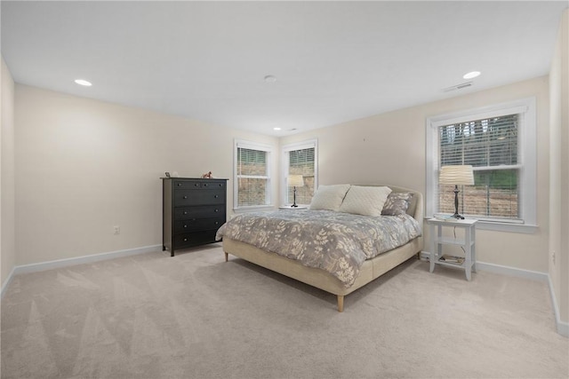 bedroom featuring baseboards, visible vents, and light carpet