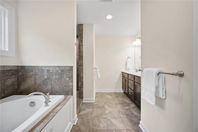 full bathroom featuring a bath, visible vents, vanity, and baseboards