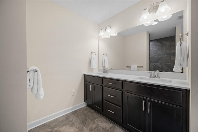 bathroom with double vanity, tile patterned floors, baseboards, and a sink