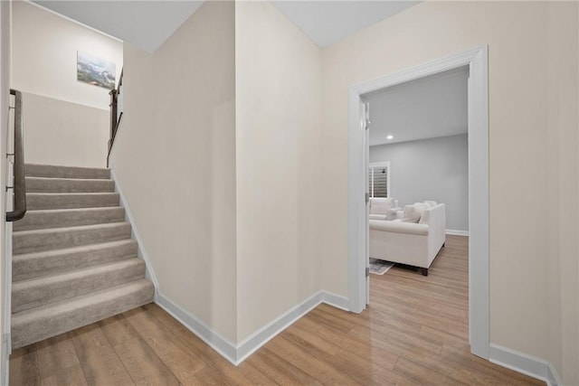 stairway featuring wood finished floors, recessed lighting, and baseboards