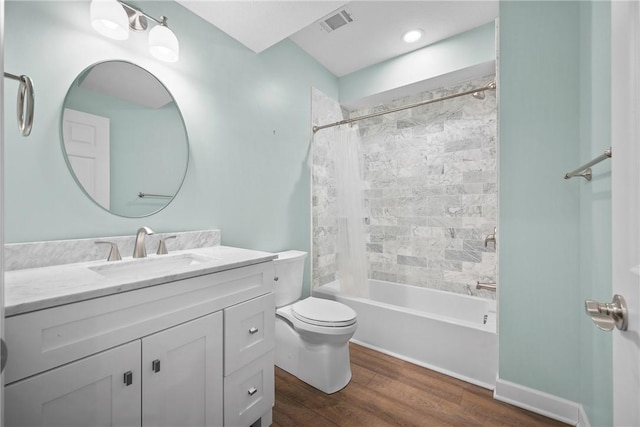 bathroom featuring shower / bath combo, vanity, toilet, visible vents, and wood finished floors