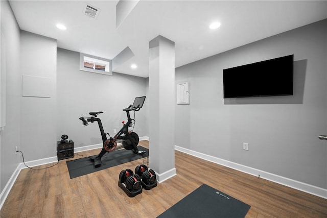 exercise area with wood finished floors, recessed lighting, visible vents, and baseboards