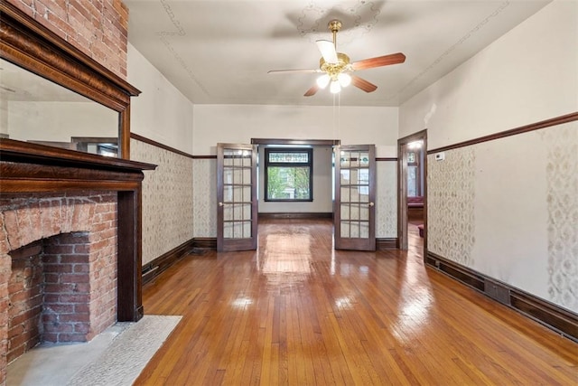 unfurnished living room featuring ceiling fan, hardwood / wood-style floors, and a fireplace