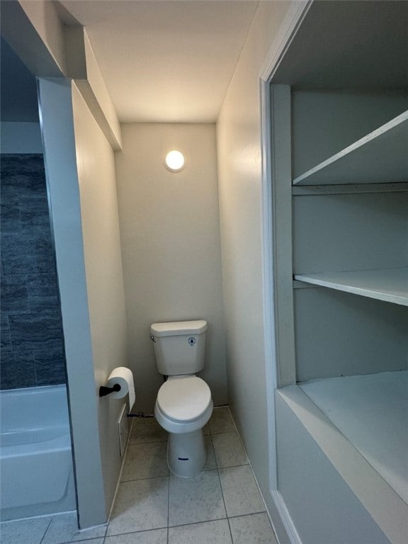 bathroom featuring toilet, tile patterned flooring, and a bathing tub